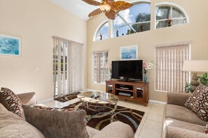Spacious living room with vaulted ceilings, natural light, and cozy seating for family gatherings.