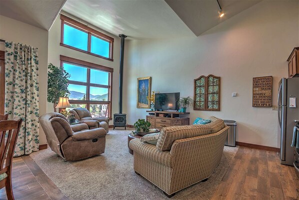 Lots of natural light from the windows, along with a cozy fireplace and big screen TV