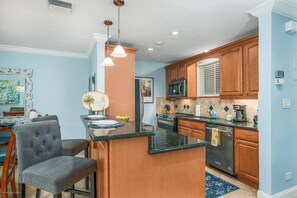 Full kitchen with stainless appliances stocked with plenty of pots, pans, dishes and stemware