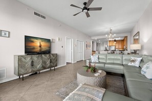 Living Room Features a Wrap Around Sectional Sofa and Cable TV
