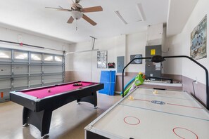 Game room featuring a pool table and air hockey for endless entertainment.