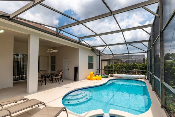Private screened pool with lounge seating, perfect for sunny relaxation and family fun.