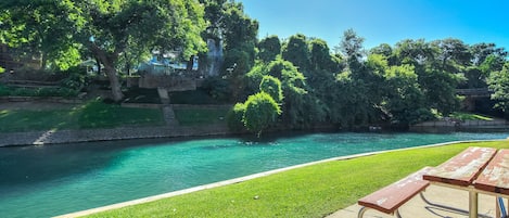 Property picnic tables on the Comal riverbank.