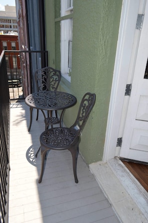 Bistro set on the balcony offers a cozy nook for coffee in the morning or cocktails as you overlook the Picayune Alley