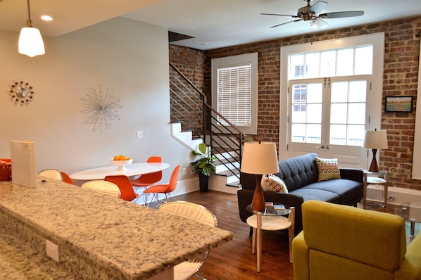 Open concetp living - dining - kitchen space with French Doors out to balcony