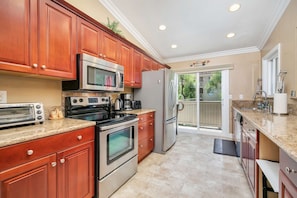 Updated kitchen with custom cabinetry, granite counters, and stainless appliances