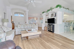 This charming open concept living space is decorated in soft, pastels, sofa, loveseat & recliner.