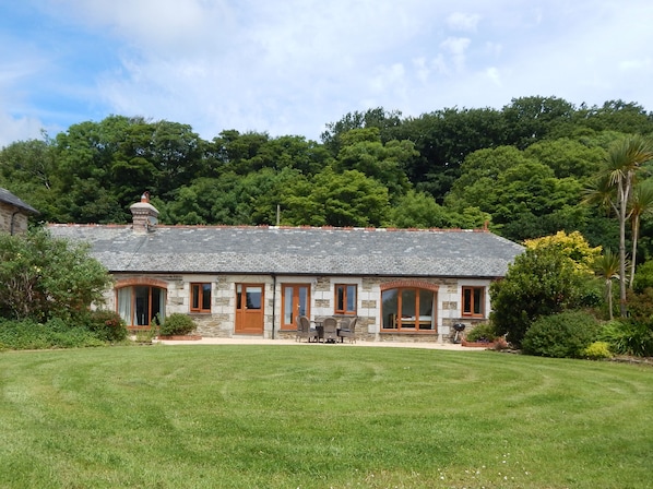 Single-story former coach house. Each room overlooks the patio and large garden.