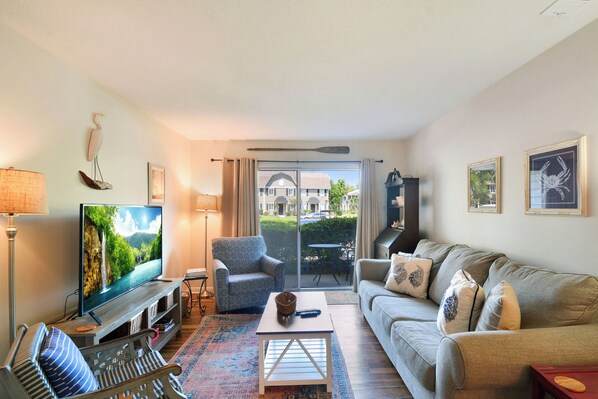 Cozy Living Room with Porch Access – Ocean Walk R1 - Breezy and bright, this Ocean Walk R1 living room invites you to unwind. Slide open the door to your patio, stream your favorite shows, or just soak up island light after a stroll to Pier Village.