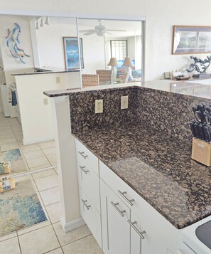 Granite topped peninsula with back to back cabinets. - Large pantry behind sliding mirrored doors
