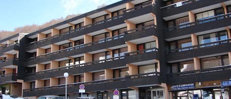 Immeuble "Les Pistes" lieu de l'appartement, Centre bourg Super-Besse, parking.