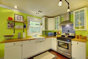 Bright Chef’s Kitchen – St. Simons Island Vacation Rental - This colorful kitchen is the heart of your St. Simons beach rental, with a gas range, farmhouse sink, and butcher block counters. Whether you're cooking up fresh seafood or a slow morning, it’s stocked and guest-ready.