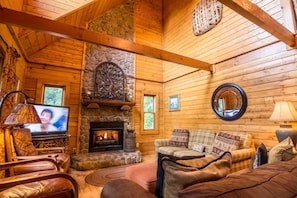 Living room with couches and chairs and gas log fireplace