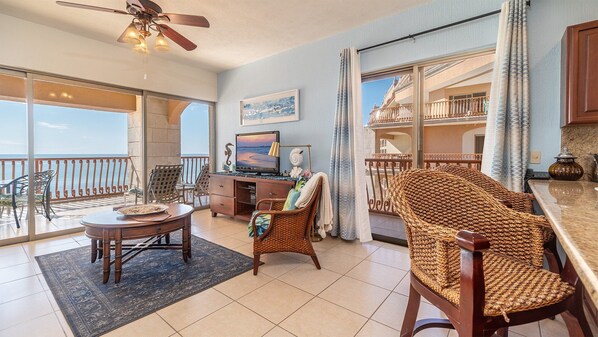 Living room with lots of windows, seating at the kitchen counter as well