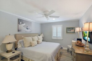 Primary Bedroom – Ocean Walk J-11 - Soft lighting, a king bed, and a flat-screen TV make this bedroom your private retreat. Sleep in, stream your favorites, or sneak in a nap before your evening stroll to the pier.