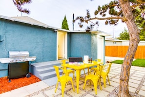 Vibrant backyard with barbecue grill and dining table.