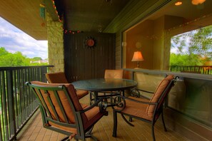 The patio is lit with festive lights, and the table seats four.