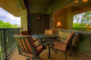 The patio is lit with festive lights, and the table seats four.