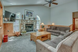 The living room, with two couches, a fireplace, TV, and a coffee table in the center of the room.