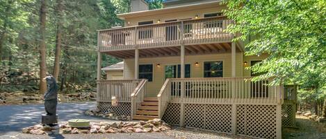 The exterior of this Lake Harmony rental, with its two patios and a bear statue out front.