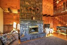 Cozy up around the stone wood-burning fireplace as you watch the flat-screen TV.
