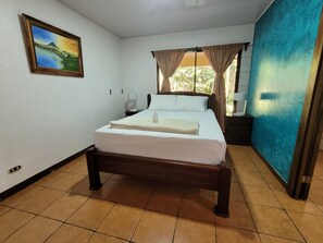 Main bedroom: queen bed, A/C unit and private bathroom