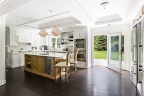 Full kitchen: 3 fridges, 3 sinks, stone counters, stacked ovens, & large island