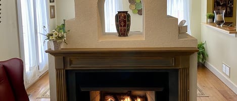 Gas-log fireplace located in the living room with dining room on other side.