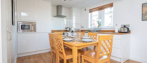 Well-equipped kitchen ideal for cooking meal and dining table for 6 persons.