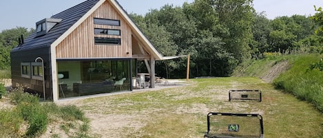 Sporty paradise surrounded by dunes with a trampoline and soccer goals