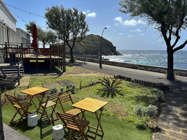 Jardim exterior com mesas e cadeiras amovíveis para desfrutar vista mar