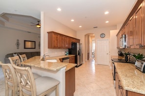Elegant, full-sized kitchen, complete with granite counter tops, stainless appliances, and abundant cupboard space.