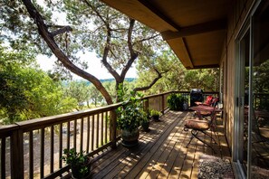Deck area with lake view, shaded by oak trees