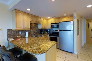 Kitchen is fully equipped with granite counters and stainless appliances.