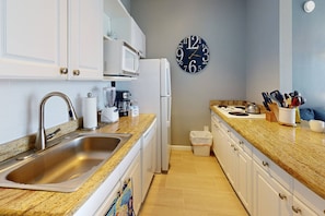 Kitchenette fully equipped with a full size refrigerator, dishwasher, and four burner stove top.