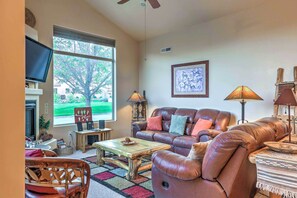 The living room boasts comfy leather furniture and a flat-screen cable TV.