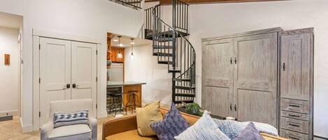 Queen size Murphy bed is located behind the sofa, spiral staircase (note the height & slope at the top) lead to the queen and twin beds.