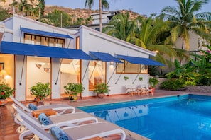 Poolside view of villa exterior during evening