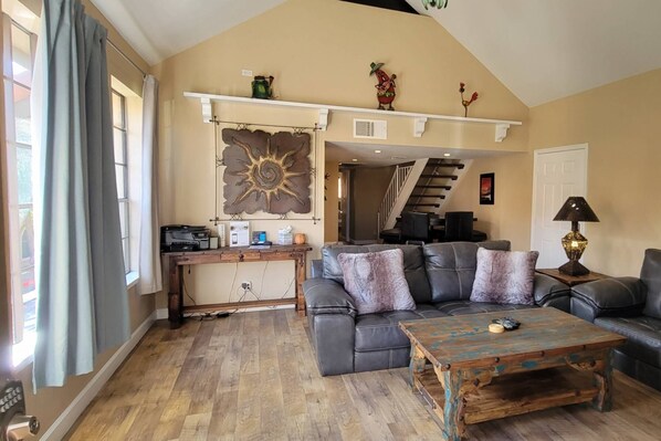 The living room area as you walk in the front door. Couch, Love Seat, Flat Screen TV and desk with printer