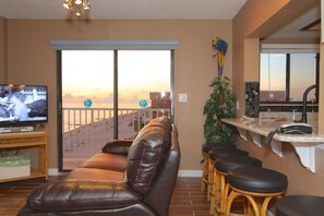 The living room has a view of the beach and extra bar stool dining