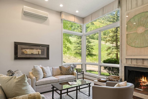 The living room features new furnishings, wood burning fireplace and incredible views of Aspen mountain