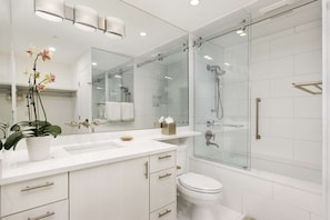 A bright newly remodeled master bath has a spacious tub and shower and a luxurious ambiance.