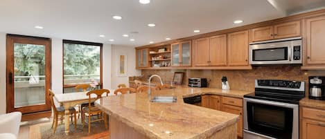 Stainless steel appliances, granite countertops, custom made dining table and a great view are found in the kitchen/dining area.