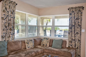 The living room has a water  view and a large couch.