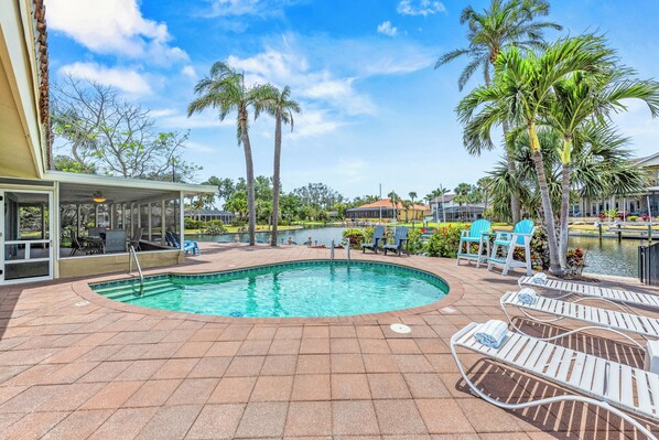 Private Pool Views at Dusk with patio, chaise lounges and screened lanai.
