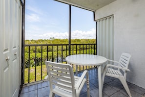 Take in lush views from the screened-in balcony - Overlooking a green, leafy mangrove preserve, the screened-in balcony is a peaceful spot to watch all sorts of birds swoop and soar against the endless blue skies. 