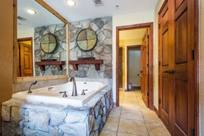 The primary suite has an oversized tub, the bathroom has a his and hers vanity, large tile countertop, large soaker tub with jets, walk-in shower and