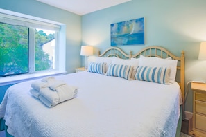 The master suite features a king bed and night stands with reading lamps.