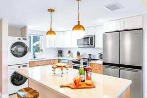 A bright modern kitchen with a washer and dryer for your convenience