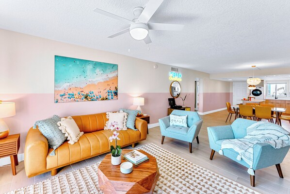 Step into a cozy living area with a 70 inch tv a record player and a surfboard